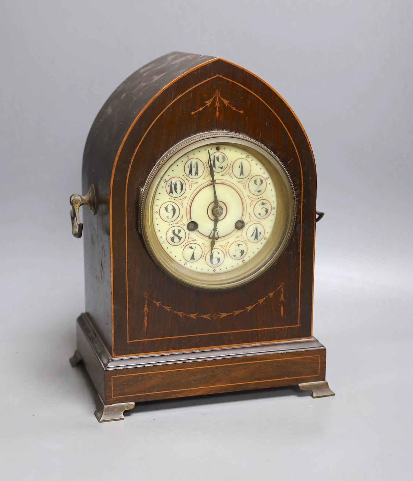 An early 20th century mahogany inlaid dome topped mantel clock, 30 cms high.